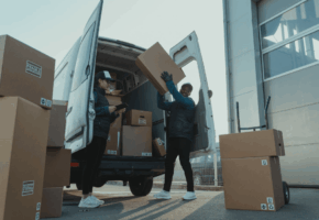 two couriers unloading boxes from a van