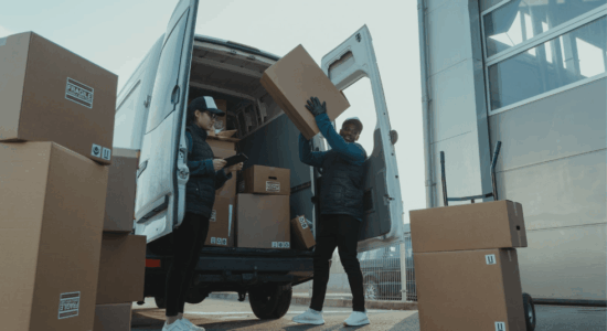 two couriers unloading boxes from a van